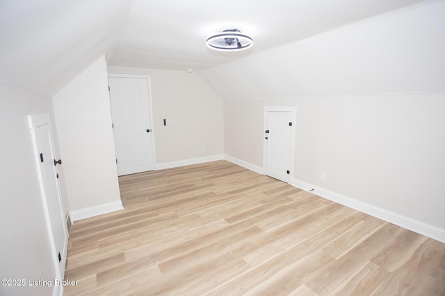 bonus room featuring lofted ceiling and light hardwood / wood-style flooring