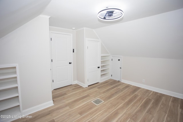 additional living space featuring light hardwood / wood-style flooring and vaulted ceiling