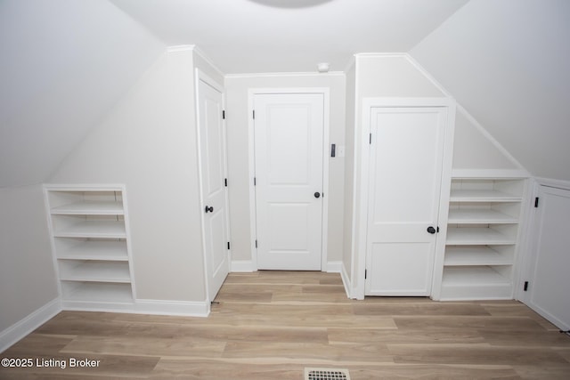 additional living space with lofted ceiling and light hardwood / wood-style flooring