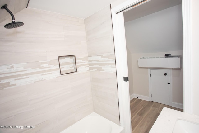 bathroom with wood-type flooring and tiled shower / bath