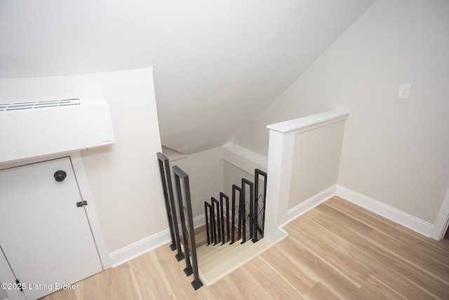 stairs featuring lofted ceiling and wood-type flooring