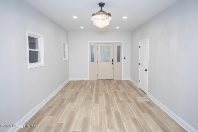 hallway featuring a chandelier and light wood-type flooring