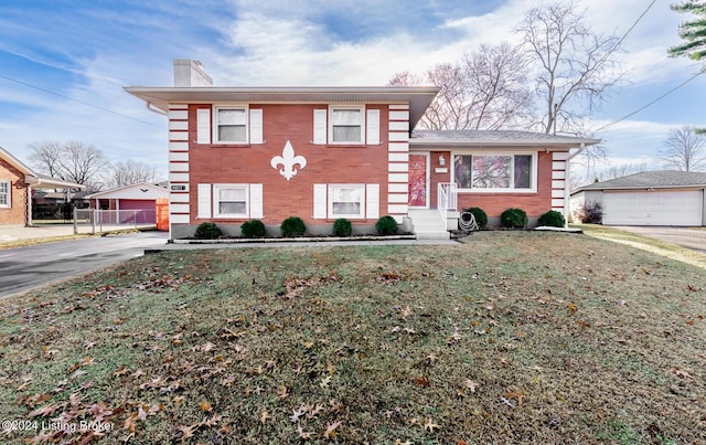 view of front of house featuring an outdoor structure, a front yard, and a garage