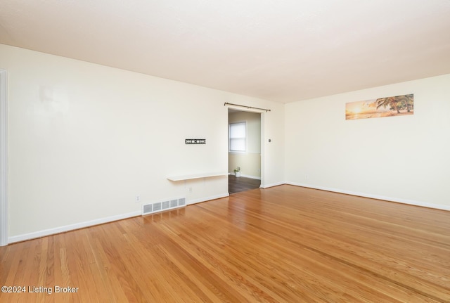 unfurnished room featuring hardwood / wood-style flooring