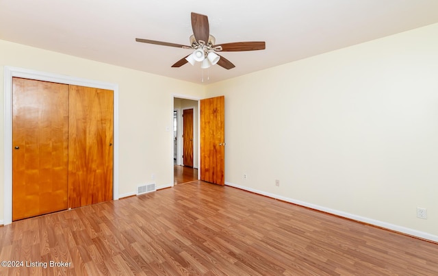 unfurnished bedroom featuring ceiling fan, light hardwood / wood-style floors, and a closet