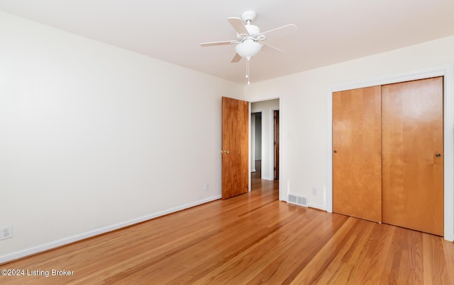 unfurnished bedroom with hardwood / wood-style floors, ceiling fan, and a closet