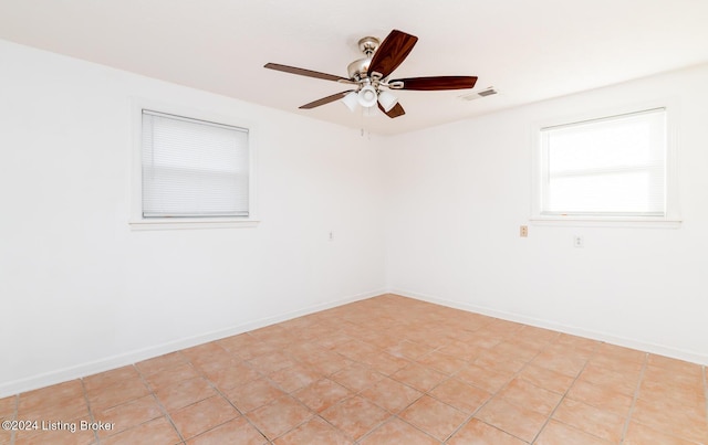 tiled spare room featuring ceiling fan