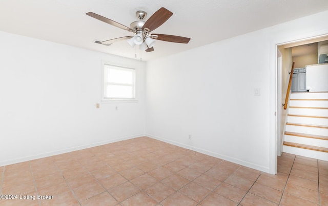 empty room with ceiling fan and light tile patterned flooring