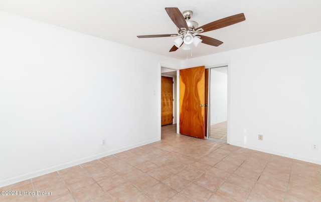 empty room featuring light tile patterned floors and ceiling fan