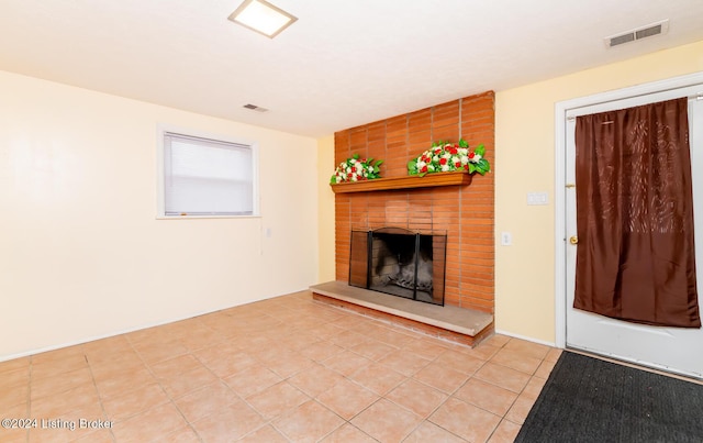 unfurnished living room featuring a fireplace and light tile patterned flooring