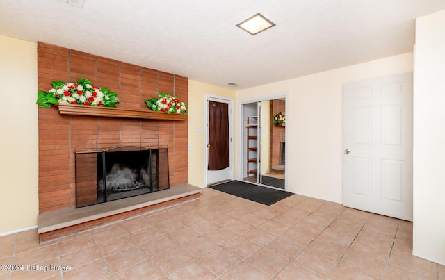 unfurnished living room with tile patterned flooring and a brick fireplace