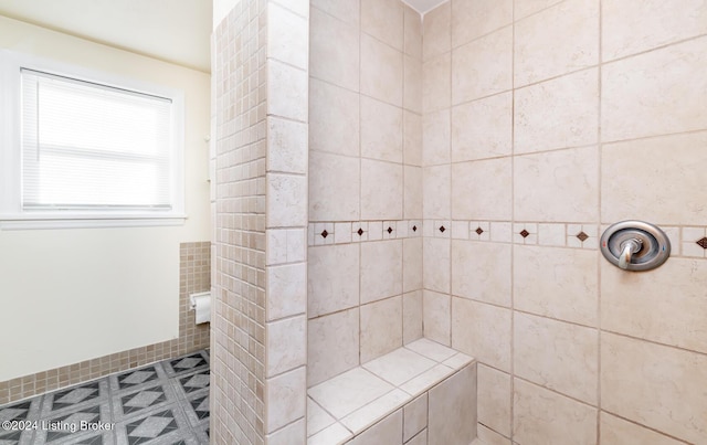 bathroom featuring tiled shower and tile patterned floors