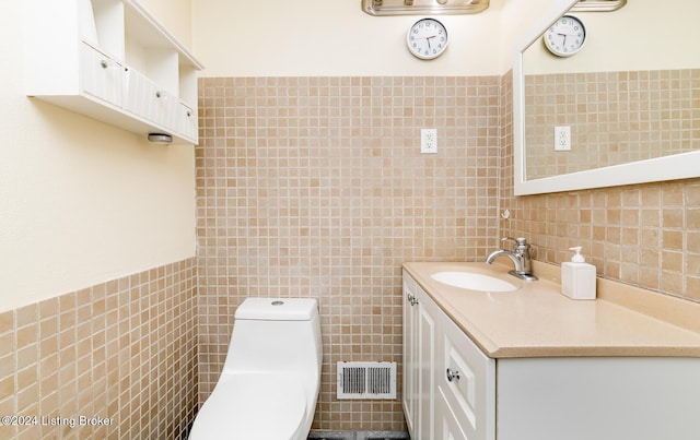 bathroom featuring vanity, tile walls, and toilet