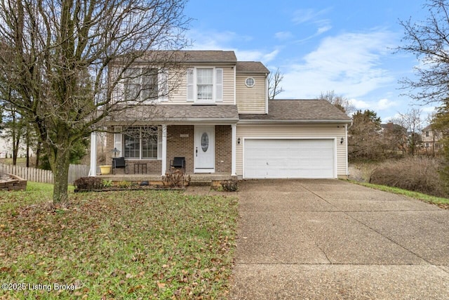 view of property featuring covered porch, a front yard, and a garage