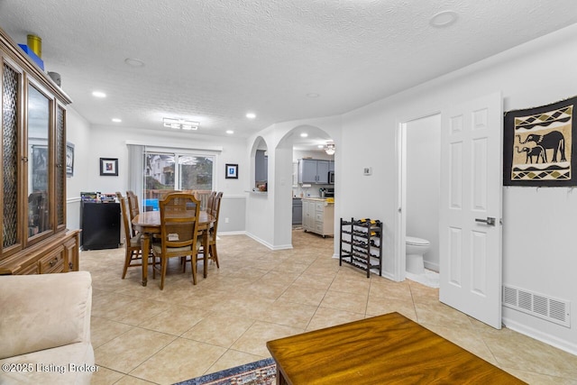 dining room featuring light tile patterned flooring and a textured ceiling