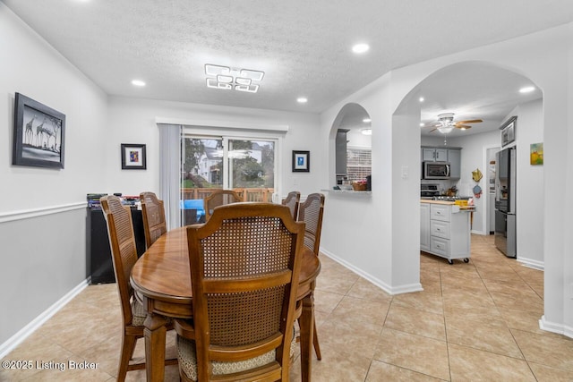 dining space with a textured ceiling, ceiling fan, and light tile patterned flooring