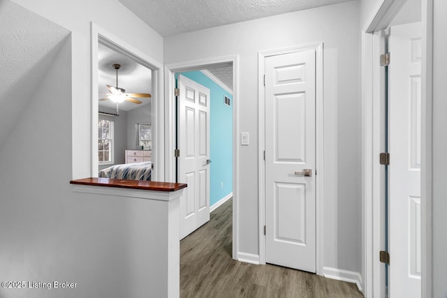 corridor featuring hardwood / wood-style floors and a textured ceiling