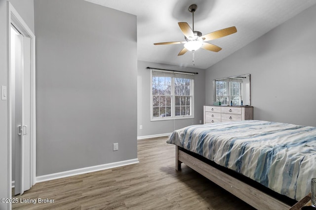 bedroom with hardwood / wood-style floors, ceiling fan, and lofted ceiling