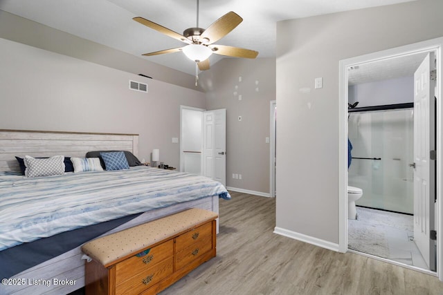 bedroom with ensuite bath, ceiling fan, vaulted ceiling, and light wood-type flooring