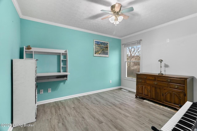 misc room featuring crown molding, ceiling fan, light hardwood / wood-style floors, and a textured ceiling