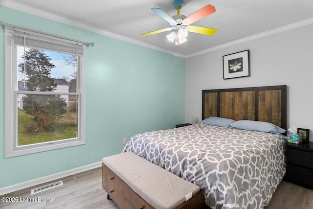 bedroom featuring ceiling fan, light hardwood / wood-style floors, and ornamental molding