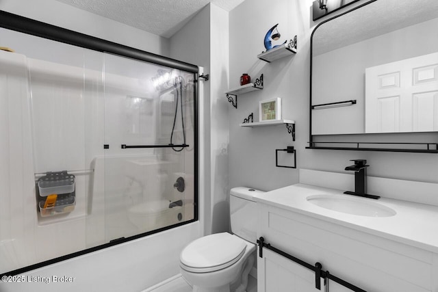 full bathroom with shower / bath combination with glass door, vanity, a textured ceiling, and toilet