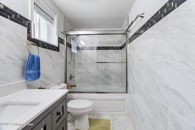 full bathroom with shower / bath combination with glass door, vanity, and toilet