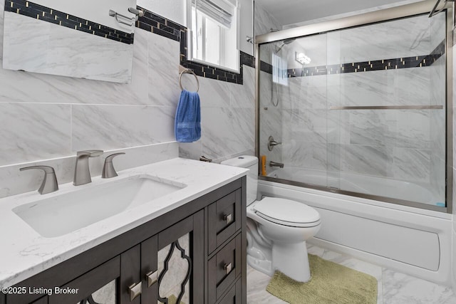 full bathroom with combined bath / shower with glass door, vanity, and toilet