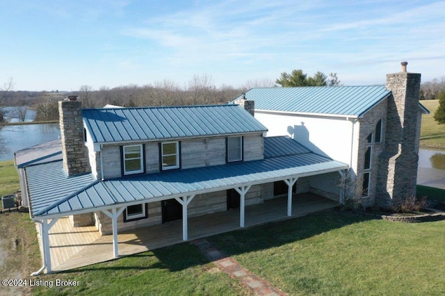 rear view of house with a yard, a patio, a water view, and cooling unit