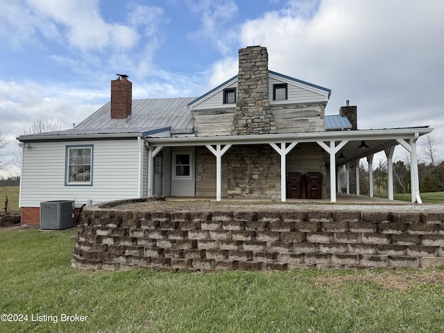 rear view of property with a lawn and cooling unit