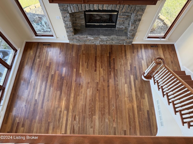 unfurnished living room featuring a healthy amount of sunlight and a stone fireplace