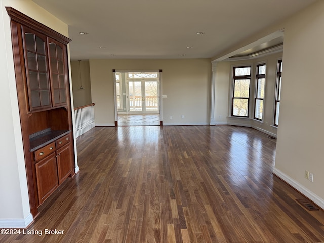 unfurnished living room with dark wood-type flooring