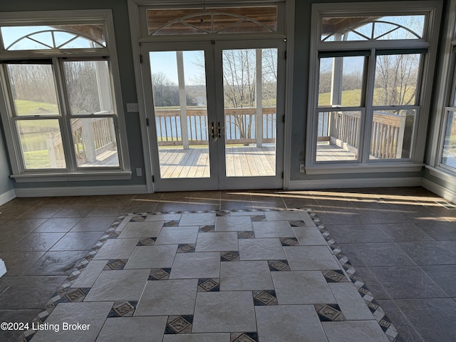 entryway with plenty of natural light, a water view, and french doors