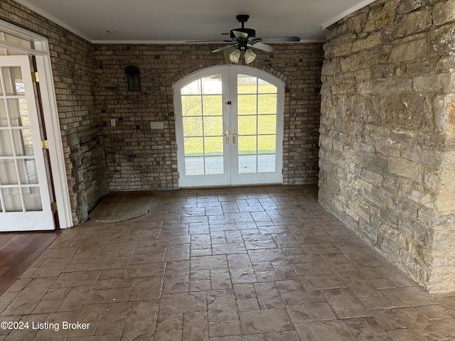 unfurnished dining area featuring ceiling fan, crown molding, and french doors