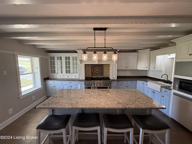 kitchen with white cabinets, sink, stainless steel stove, light stone countertops, and beamed ceiling