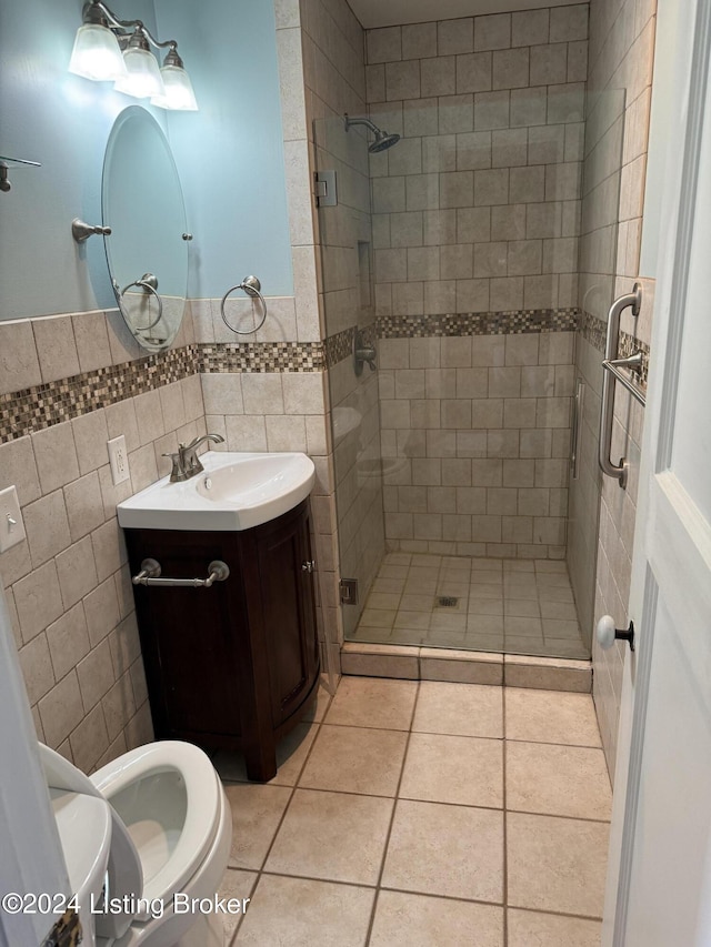 bathroom featuring tile patterned flooring, vanity, an enclosed shower, and tile walls