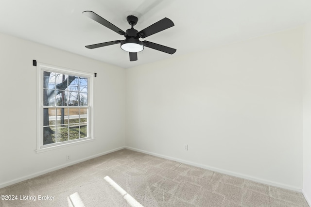 spare room featuring light colored carpet and ceiling fan