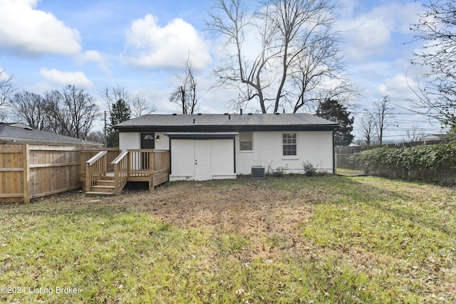 rear view of property with a lawn, cooling unit, and a deck