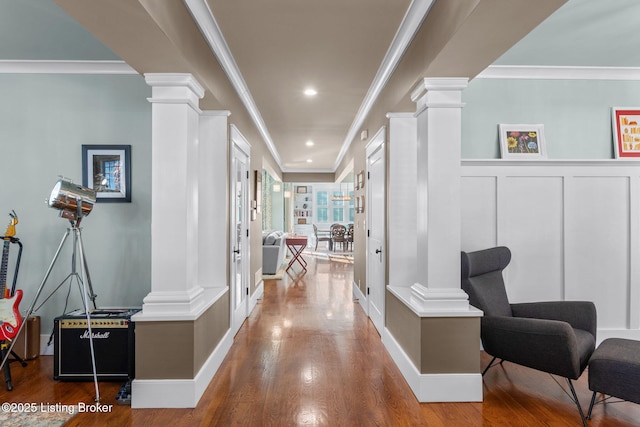 hallway with ornate columns and hardwood / wood-style floors