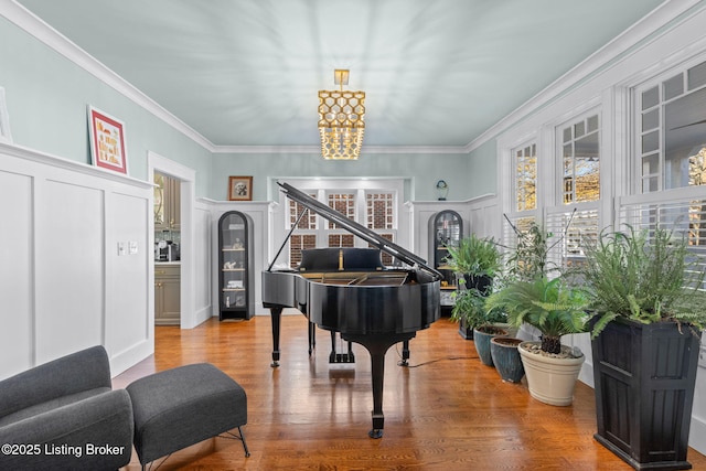 miscellaneous room with an inviting chandelier, crown molding, and wood-type flooring