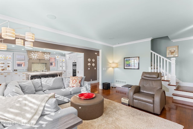 living room with crown molding and dark wood-type flooring