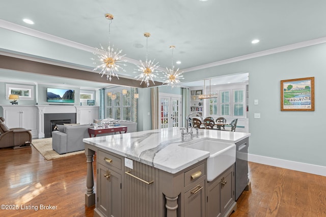 kitchen with dishwasher, a kitchen island with sink, pendant lighting, and gray cabinetry