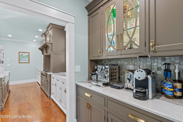 kitchen with crown molding, decorative backsplash, and light wood-type flooring