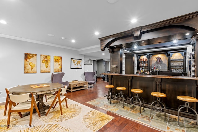 bar featuring ornamental molding and hardwood / wood-style floors