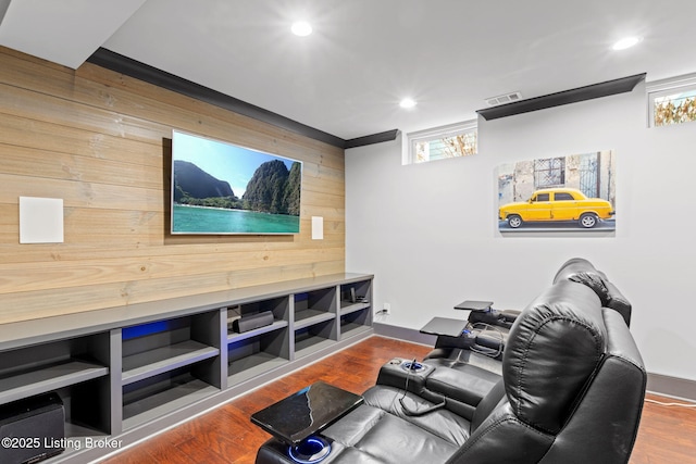 cinema room with wood-type flooring and wooden walls