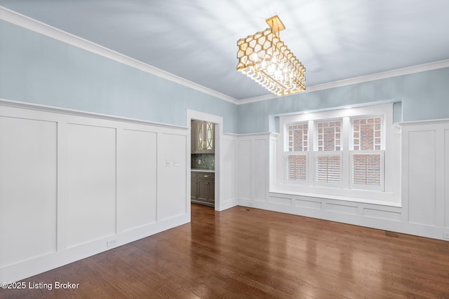 unfurnished dining area with crown molding, dark hardwood / wood-style floors, and a notable chandelier