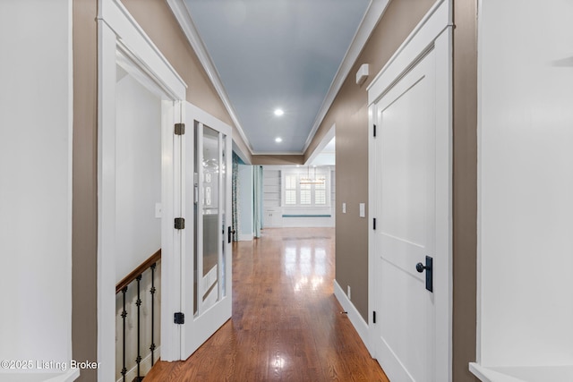 corridor with hardwood / wood-style floors and crown molding