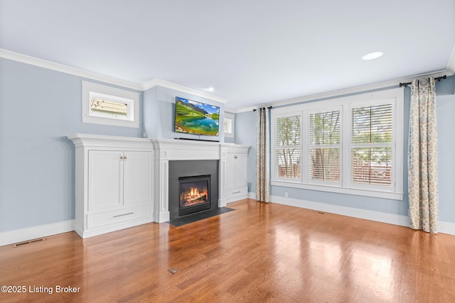 unfurnished living room featuring ornamental molding, light hardwood / wood-style flooring, and plenty of natural light