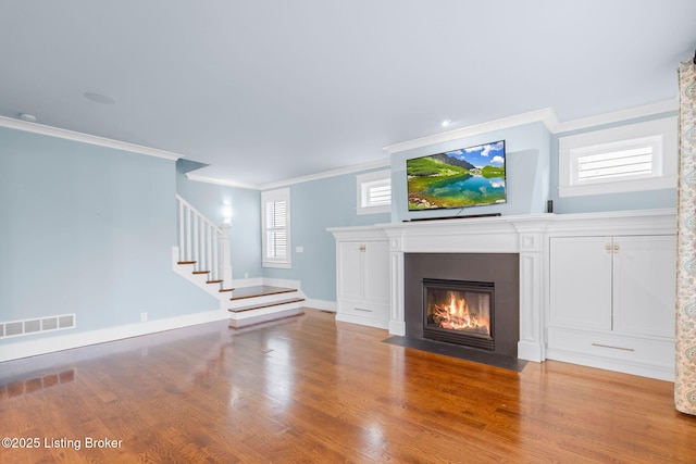 unfurnished living room with ornamental molding and light hardwood / wood-style flooring