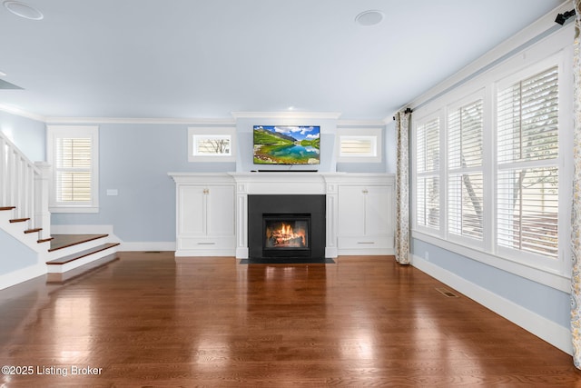 unfurnished living room with crown molding and dark hardwood / wood-style floors